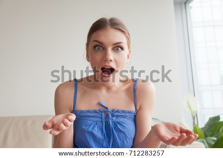 Interested surprised young woman looking at camera with open mouth questioning gesture, amazed teen girl with confused face expression shocked by unbelievable news, curious about details, head shot Royalty-Free Stock Photo #712283257