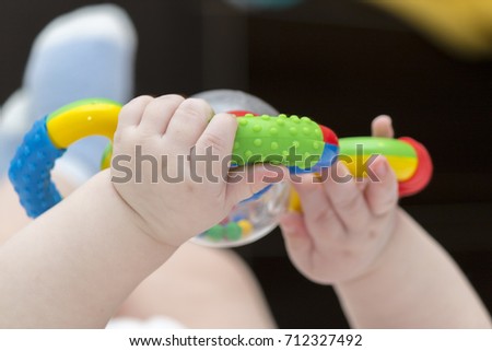 The baby is playing with a toy