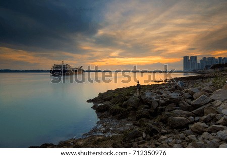 The majestic and beautiful sunset view at a bay with high rise condominium and cruise as point of interest.Image contain certain grain or noise and soft focus when view at full resolution

