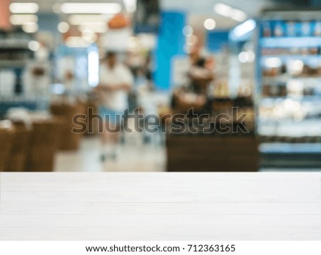 White wooden board empty table in front of blurred background. Perspective table over blur in supermarket - can be used for display or montage your products. Mockup for display of product.