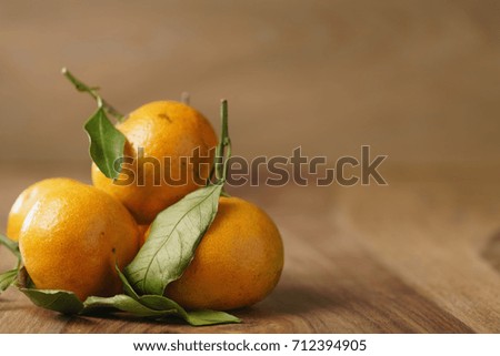 organic tangerines with leaves on wood table