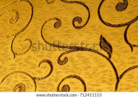 Texture, background, pattern. Damask fabric with shiny patterns on a matte background .. Golden color.  Abstract pattern. Luxury golden wallpaper. Vintage wave pattern