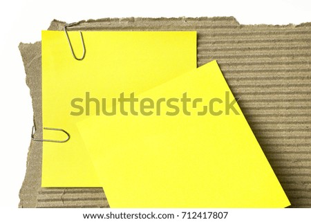 Macro image of cardboard and yellow post it notes, isolated on white