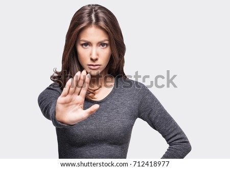 Young serious beautiful woman showing stop sign. Prohibition symbol