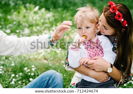 Mother hug son with candy.  Happy funny family on the background grass on nature. Boy with candy. Close up.