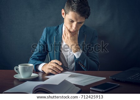 Man businessman signs important legal documents on the desktop with Cup of coffee