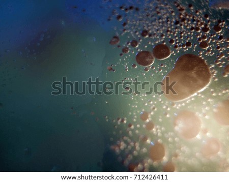 Watercolor paint dissolves in water droplets on the glass, backlighting from different directions, large magnification, bokeh, Colored abstractions