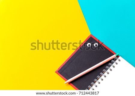 Pastel office desk with open notebook and pen on two tone background. The eyes is on a notebook