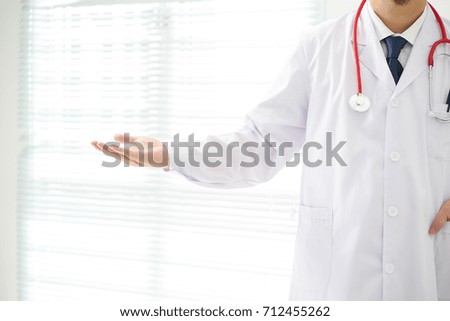 Unknown doctor posing pointing away advertising your product.