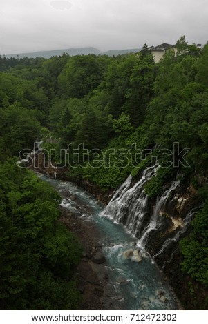 Beautiful Shirogane Falls dropping into a blue river, Biei, Hokkaido, Japan