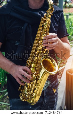 Close up of saxophone player's hands playing jazz music. Street saxophonist playing sax alto