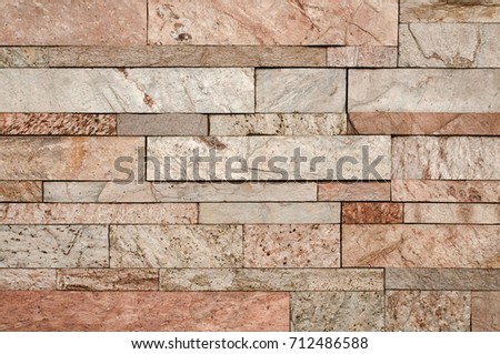 Grunge brown stone wall tiles texture. Wall panel natural brown,orange stone dirty,dust with pattern design or abstract background.
