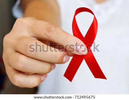 The symbolic conception of the world day of fight against AIDS. The red ribbon in the hands of a young woman.