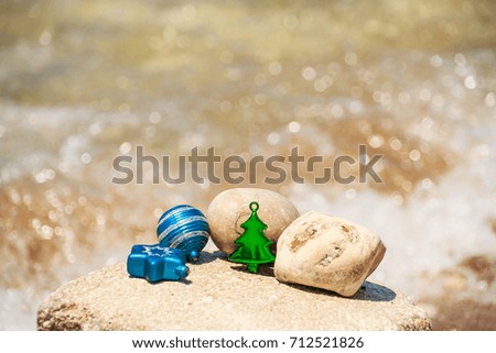 Merry Christmas and Happy New Year background with decorations on the tropical beach near ocean.Christmas decorations on a beach sand against water