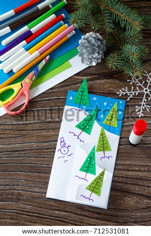The child makes a greeting card Christmas. Made with his own hands. Children's art project craft for kids. Craft for children.