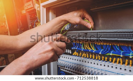 The man is repairing the switchboard voltage with automatic switches. Electrical background Royalty-Free Stock Photo #712538818