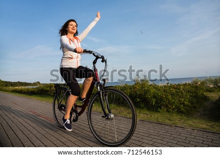 Young woman riding bike at seaside 