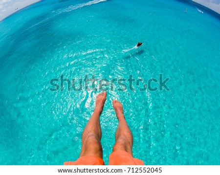View of feet parasailing with the speed boat in the sea background. Royalty-Free Stock Photo #712552045
