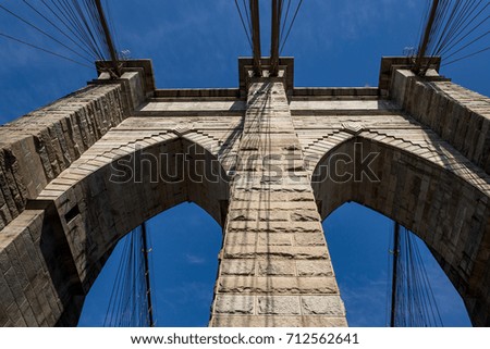 Brooklyn Bridge in bright day light against blue sky, New York.