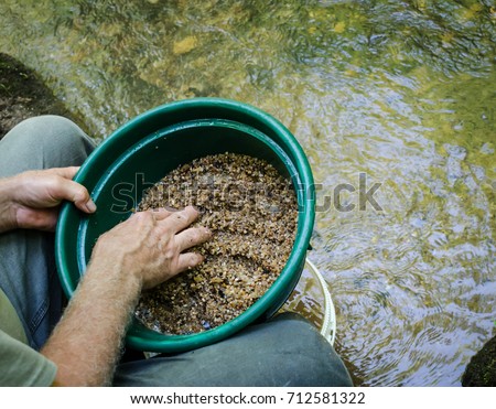 Gold panning and gem mining.  Prospecting tool of classifier used to sift and sort material. Classify mineral rich soil, dirt, pebbles and stones. Prepare soil to pan. Fun, adventure and recreation. Royalty-Free Stock Photo #712581322