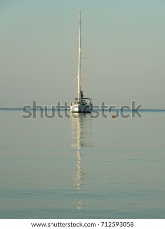 Yacht in the bright sea waters after sunrise. Amoudia, Ionian Sea, Greece.