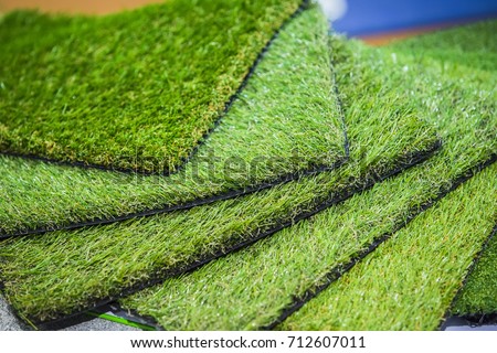 Green artificial turf rolled. Probes examples of artificial turf, floor coverings for playgrounds. Royalty-Free Stock Photo #712607011