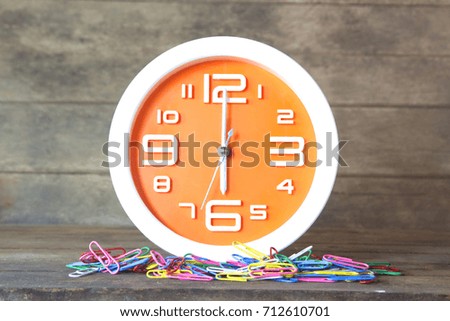 Orange clock on a wooden table.