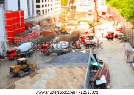 Blurry image of construction worker on site and machinery on street 