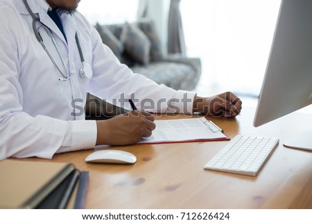 doctor sits  in the clinic writing  a prescription and writes medical history