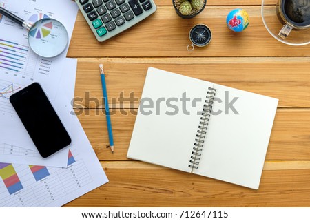 Office desk table with notebook,business documents,smart phone,pencil,glasses,calculator and cup of coffee.Top view.