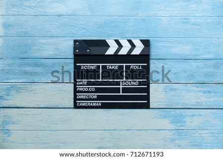 movie clapper on blue wood table ; film, cinema and video photography concept, retro style