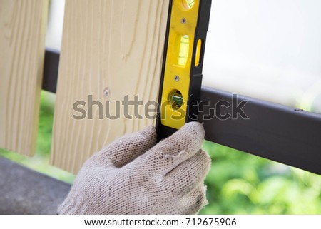A picture of a person making a gate ,A construction worker.