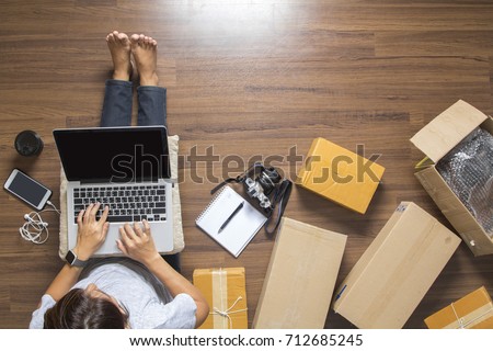Top view of women working laptop computer from home on wooden floor with postal parcel, Selling online ideas concept Royalty-Free Stock Photo #712685245