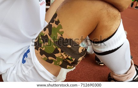 Football player who got injured with cramp  on leg's muscles  background