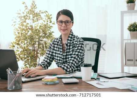 confident happy female office worker doing company work at home and looking at camera smiling.