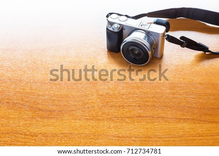 digital photography concept with mirrorless camera on wooden table with room for text or copy space