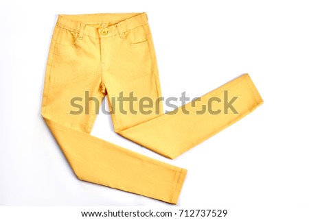 Girls beautiful yellow skinny trousers. Modern pockets yellow trousers for teenagers isolated on white background. Youth summer fashion apparel. Royalty-Free Stock Photo #712737529