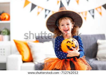happy laughing child girl in witch costume to halloween
