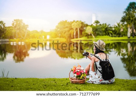 Asian woman photographer taking photo beside the marsh.