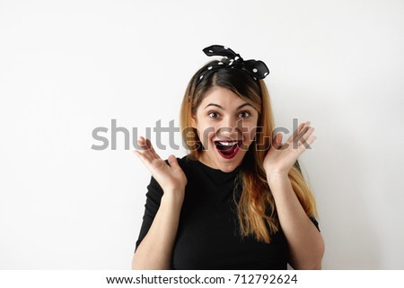 Genuine human emotions, feelings, attitude and reaction. Picture of amazed fascinated young European female with mouth wide opened gesturing in excitement while receiving present on her birthday