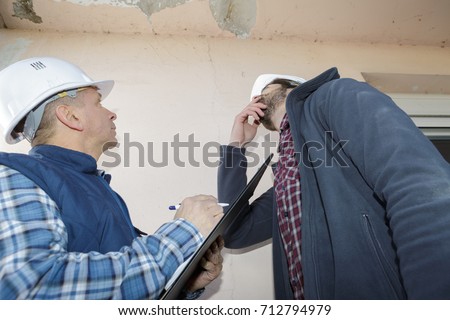 builders inspecting roof damage Royalty-Free Stock Photo #712794979