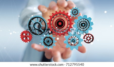 Businessman on blurred background holding floating gear icons in his hand 3D rendering