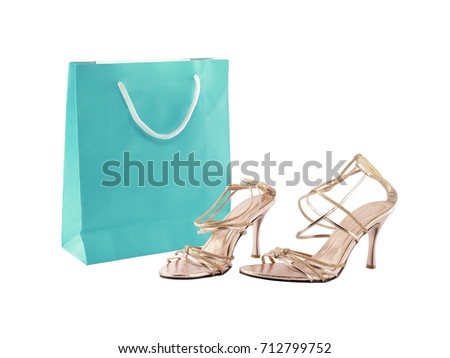 pair of beige women strappy high heel shoes and empty turquoise blue paper shopping bag with white twine rope for carry isolated on white background, shopping for woman fashion clothes
