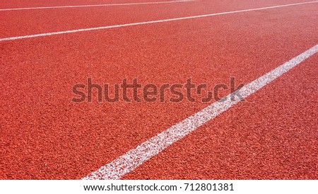 Sport Background. Running track in outdoor. Red Jogging rubberized athletic track with a white dividing lines at the stadium under the open sky.
