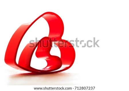 Valentine's Day. Red heart as a form for baking sweet cookies on a white background. Two red hearts. 