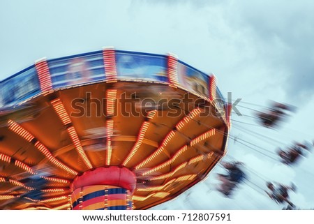 People ride a chairoplane in an amusement park