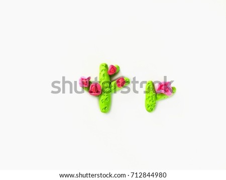Cute cactus tree with pink flower made from plasticine (clay)put in the center place on a white background