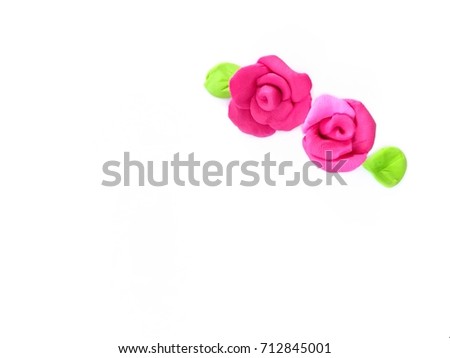Beautiful pink roses flower with green leaves made from plasticine (clay)placed in the upper right corner. On a white background