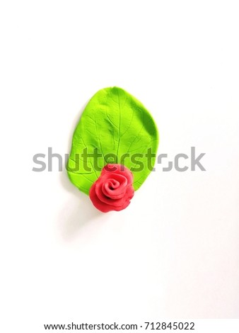 Cute green leaf with rose pink flower made from plasticine (clay)put in the center place on a white background