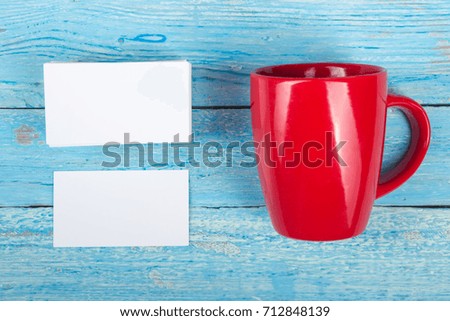 Blank business cards, red cup on the wooden table. Template for ID. Top view